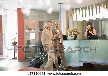 Business people rolling luggage in hotel View Large Photo Image Stock Image - Business people rolling luggage in hotel. Fotosearch