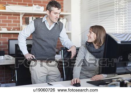 Stock Photograph - Business people talking at desk. Fotosearch