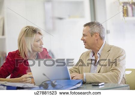 Stock Image - Business people talking in office. Fotosearch