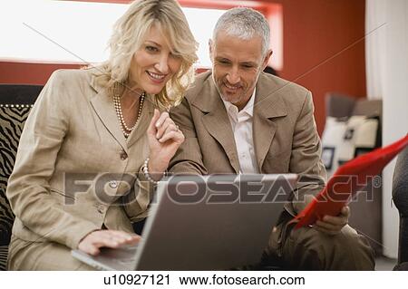 Stock Image - Business people working in lounge. Fotosearch