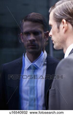 Stock Image - Businessman admiring himself in window. Fotosearch