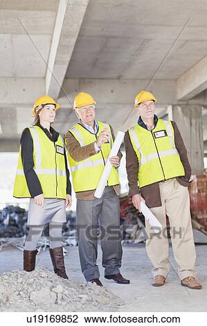 Stock Image - Businessman and workers talking on site. Fotosearch