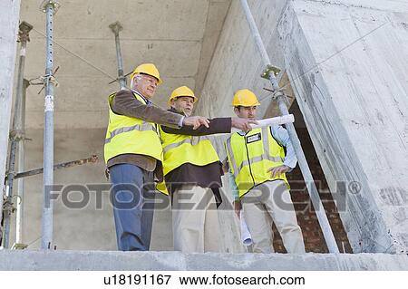 Businessman and workers talking on site View Large Photo Image Stock Photo - Businessman and workers talking on site. Fotosearch