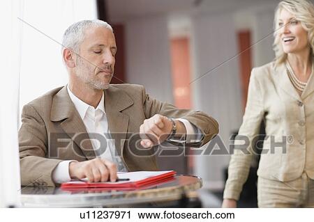 Businessman checking his watch View Large Photo Image Stock Image - Businessman checking his watch. Fotosearch
