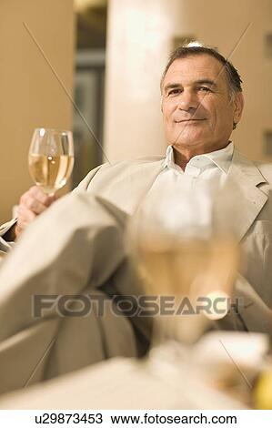 Stock Image - Businessman having glass of wine. Fotosearch