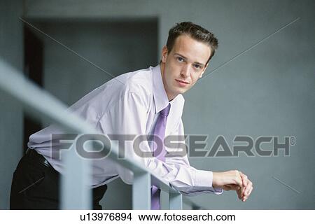 Picture - Businessman leaning on banister. Fotosearch