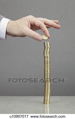 Businessman making stack of coins View Large Photo Image Stock Photo - Businessman making stack of coins. Fotosearch