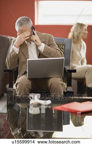 Businessman on phone using laptop View Large Photo Image Picture - Businessman on phone using laptop. Fotosearch