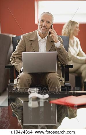 Businessman on phone using laptop View Large Photo Image Picture - Businessman on phone using laptop. Fotosearch