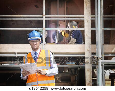 Stock Photo - Businessman on shipbuilding site. Fotosearch