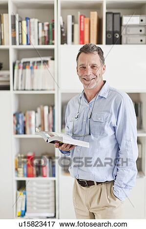 Businessman reading book in office View Large Photo Image Stock Photo - Businessman reading book in office. Fotosearch