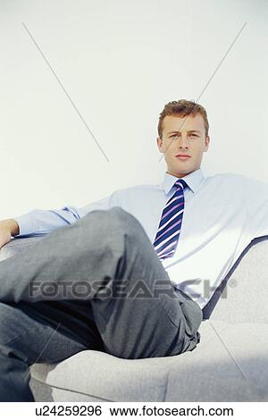 Businessman relaxing on couch View Large Photo Image Stock Photograph - Businessman relaxing on couch. Fotosearch