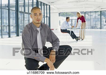 Stock Photo - Businessman sitting in office. Fotosearch