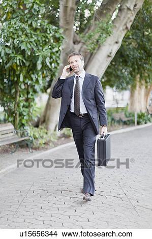Businessman talking on cell phone View Large Photo Image Picture - Businessman talking on cell phone. Fotosearch