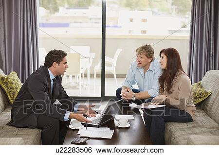 Stock Photograph - Businessman talking with couple. Fotosearch