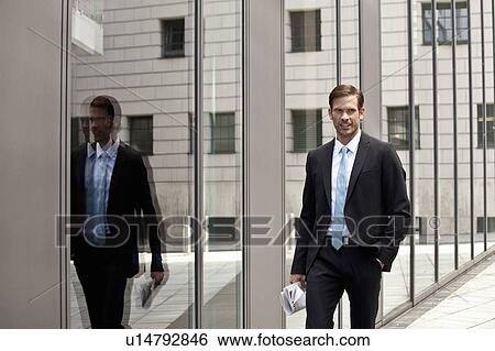 Businessman walking on city street View Large Photo Image Stock Photograph - Businessman walking on city street. Fotosearch