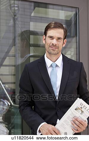 Picture - Businessman with newspaper outdoors. Fotosearch
