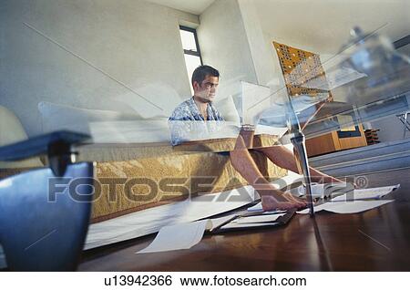 Businessman working in living room View Large Photo Image Stock Photograph - Businessman working in living room. Fotosearch
