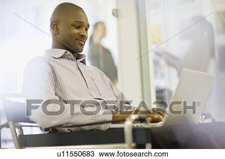 Businessman working on laptop View Large Photo Image Stock Image - Businessman working on laptop. Fotosearch