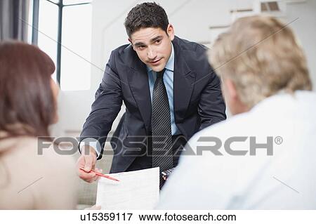Stock Photo - Businessman working with couple. Fotosearch
