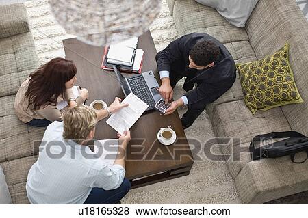 Stock Photo - Businessman working with couple. Fotosearch