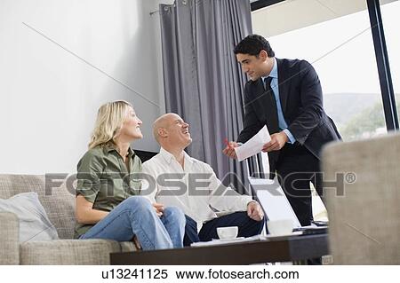 Stock Photography - Businessman working with couple. Fotosearch