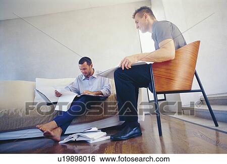 Businessmen working in living room View Large Photo Image Stock Photograph - Businessmen working in living room. Fotosearch