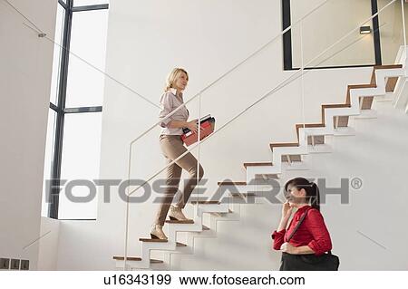 Businesswoman climbing stairs in office View Large Photo Image Stock Photo - Businesswoman climbing stairs in office. Fotosearch