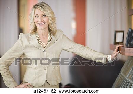 Businesswoman leaning on mantelpiece View Large Photo Image Stock Image - Businesswoman leaning on mantelpiece. Fotosearch