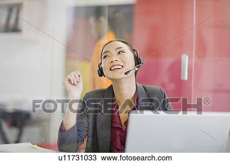 Businesswoman on headset at desk View Large Photo Image Stock Image - Businesswoman on headset at desk. Fotosearch