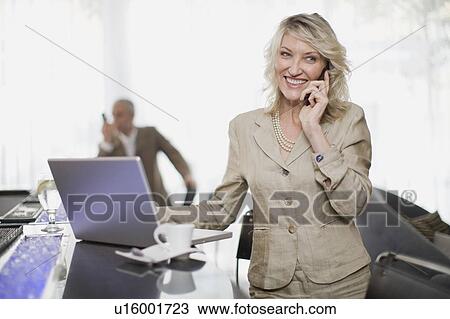 Businesswoman on phone using laptop View Large Photo Image Stock Image - Businesswoman on phone using laptop. Fotosearch