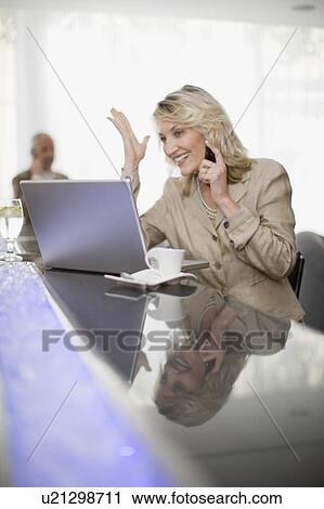 Businesswoman on phone using laptop View Large Photo Image Stock Image - Businesswoman on phone using laptop. Fotosearch