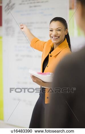 Businesswoman pointing to office board View Large Photo Image Stock Image - Businesswoman pointing to office board. Fotosearch