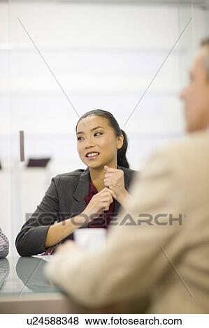 Stock Photo - Businesswoman sitting in conference. Fotosearch