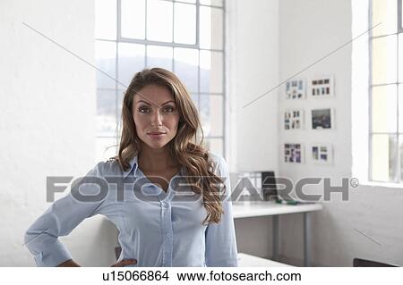 Picture - Businesswoman standing in office. Fotosearch