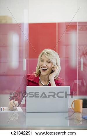Stock Image - Businesswoman talking on cell phone. Fotosearch