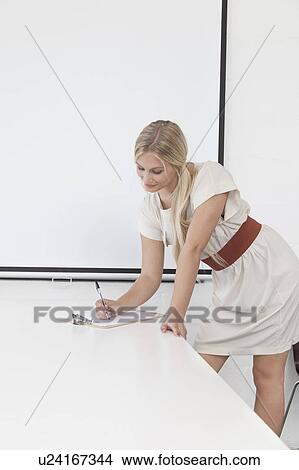 Businesswoman writing on clipboard View Large Photo Image Picture - Businesswoman writing on clipboard. Fotosearch