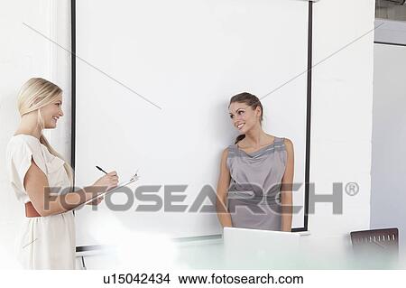 Picture - Businesswomen working together in office. Fotosearch