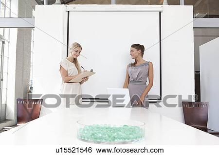 Stock Photograph - Businesswomen working together in office. Fotosearch