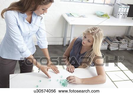 Businesswomen working with glass beads View Large Photo Image Stock Photograph - Businesswomen working with glass beads. Fotosearch