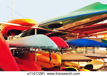 Stock Image - Canoes stacked on racks. Fotosearch
