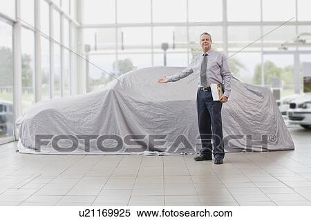 Car salesman displaying car under cloth View Large Photo Image Stock Photography - Car salesman displaying car under cloth. Fotosearch