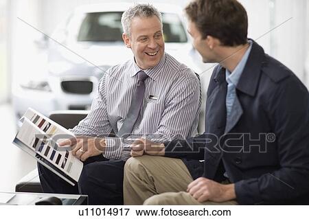 Stock Photo - Car salesman talking with customer. Fotosearch
