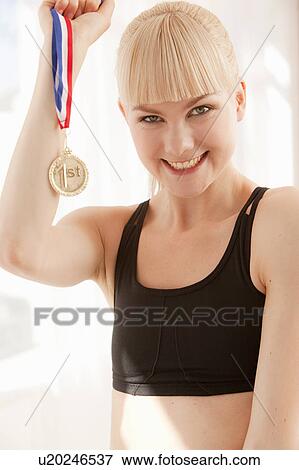 Cheering athlete holding gold medal View Large Photo Image Stock Photo - Cheering athlete holding gold medal. Fotosearch