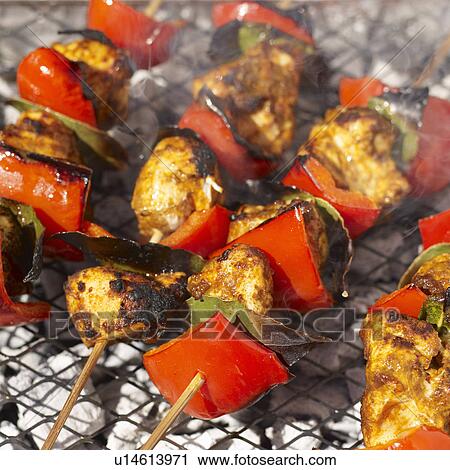 Stock Image - Chicken tikka kebabs on grill. Fotosearch