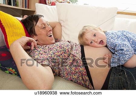 Stock Photo - Child listening to mother’s belly. Fotosearch