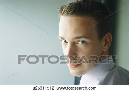 Stock Image - Close up of businessman’s smiling face. Fotosearch