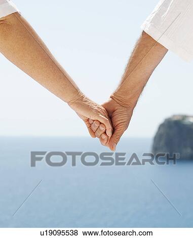 Close up of couple holding hands View Large Photo Image Stock Photo - Close up of couple holding hands. Fotosearch