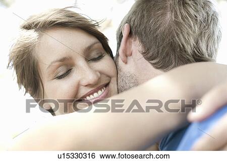 Close up of couple hugging View Large Photo Image Stock Photograph - Close up of couple hugging. Fotosearch
