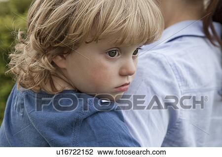 Stock Image - Close up of toddler in mother’s arms. Fotosearch